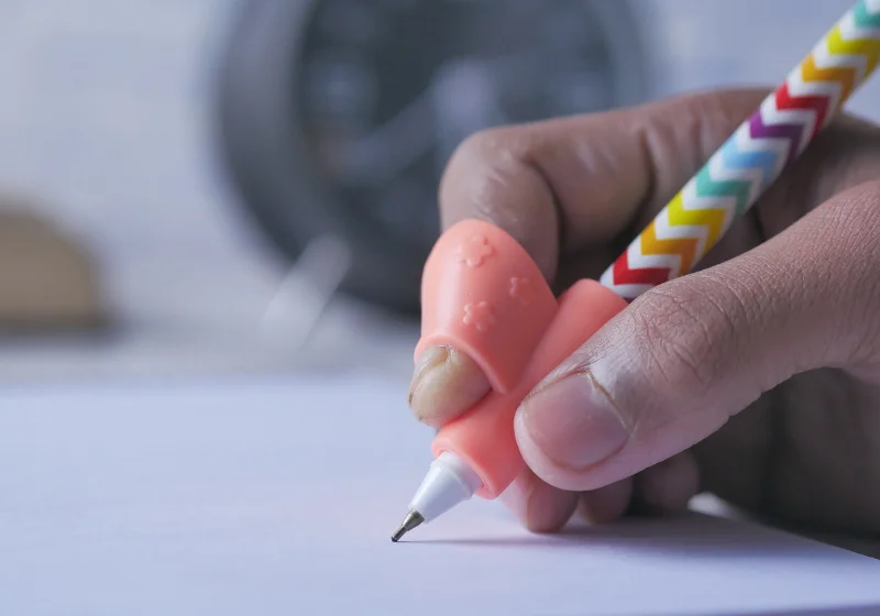 Correct pencil grip being supported with a moulded grip aid during handwriting therapy