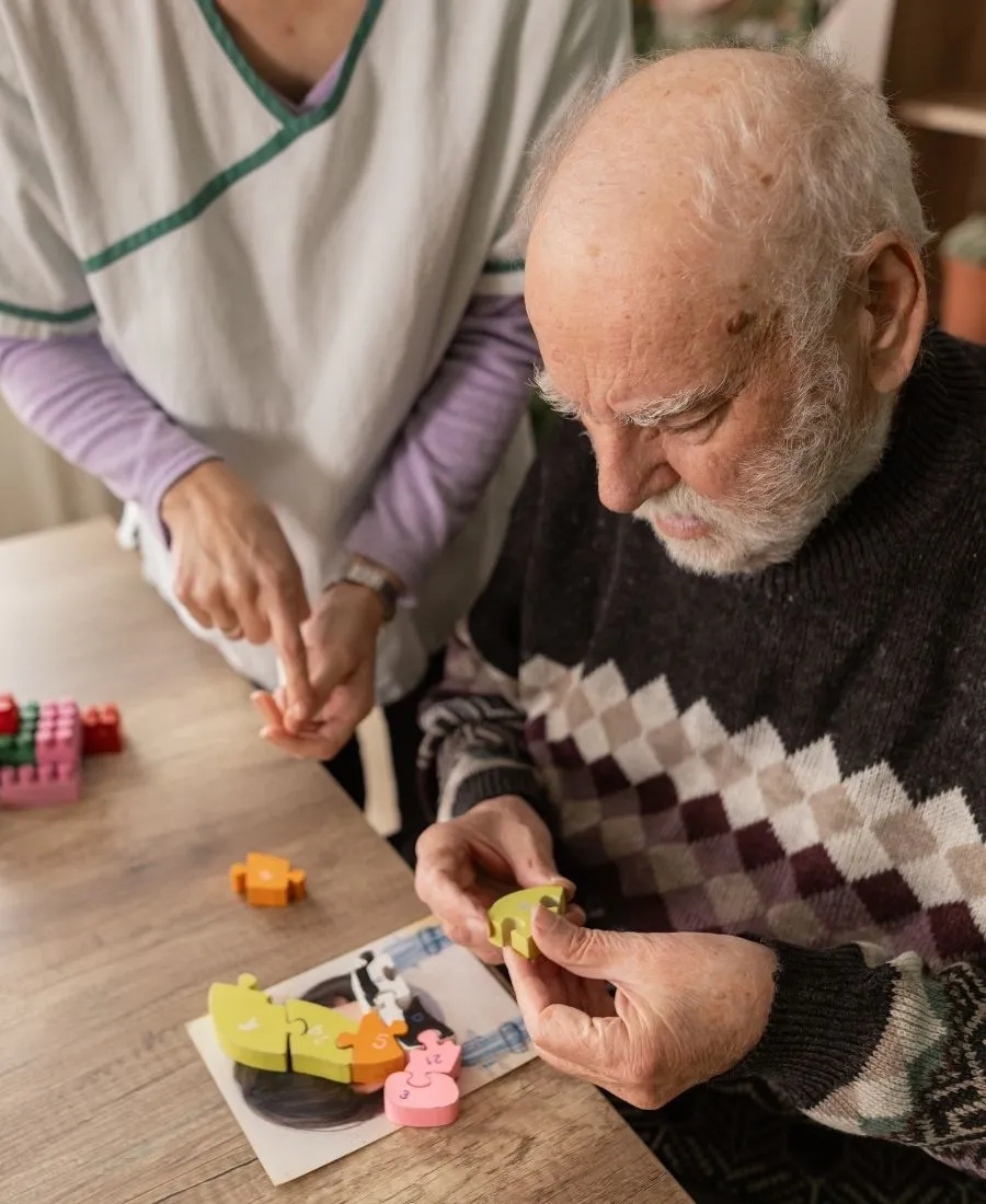 Occupational therapist supporting an older adult during a therapy session