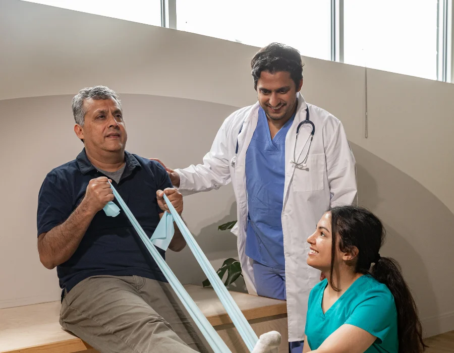 Physiotherapist guiding a patient through a resistance band exercise from their personalised physiotherapy plan