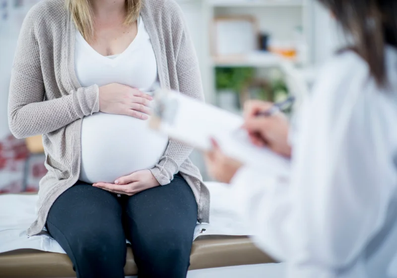 Pregnant woman being assessed by a clinician for pregnancy-related postural change