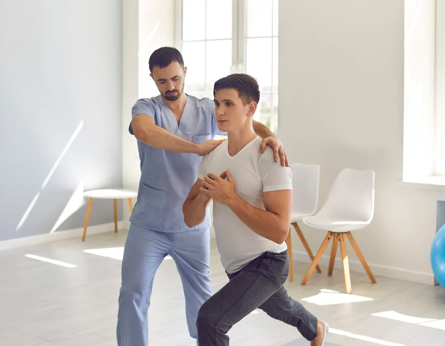 Physiotherapist guiding a patient through a lunge during a dynamic posture assessment