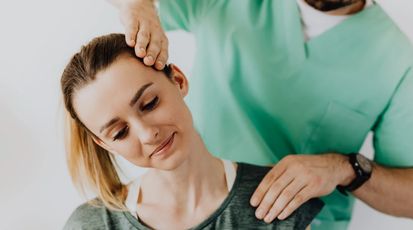 Physiotherapist performing neck and shoulder soft tissue therapy during posture correction treatment